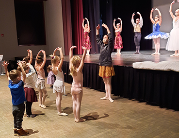 ballet instructors on stage teaching children to dance